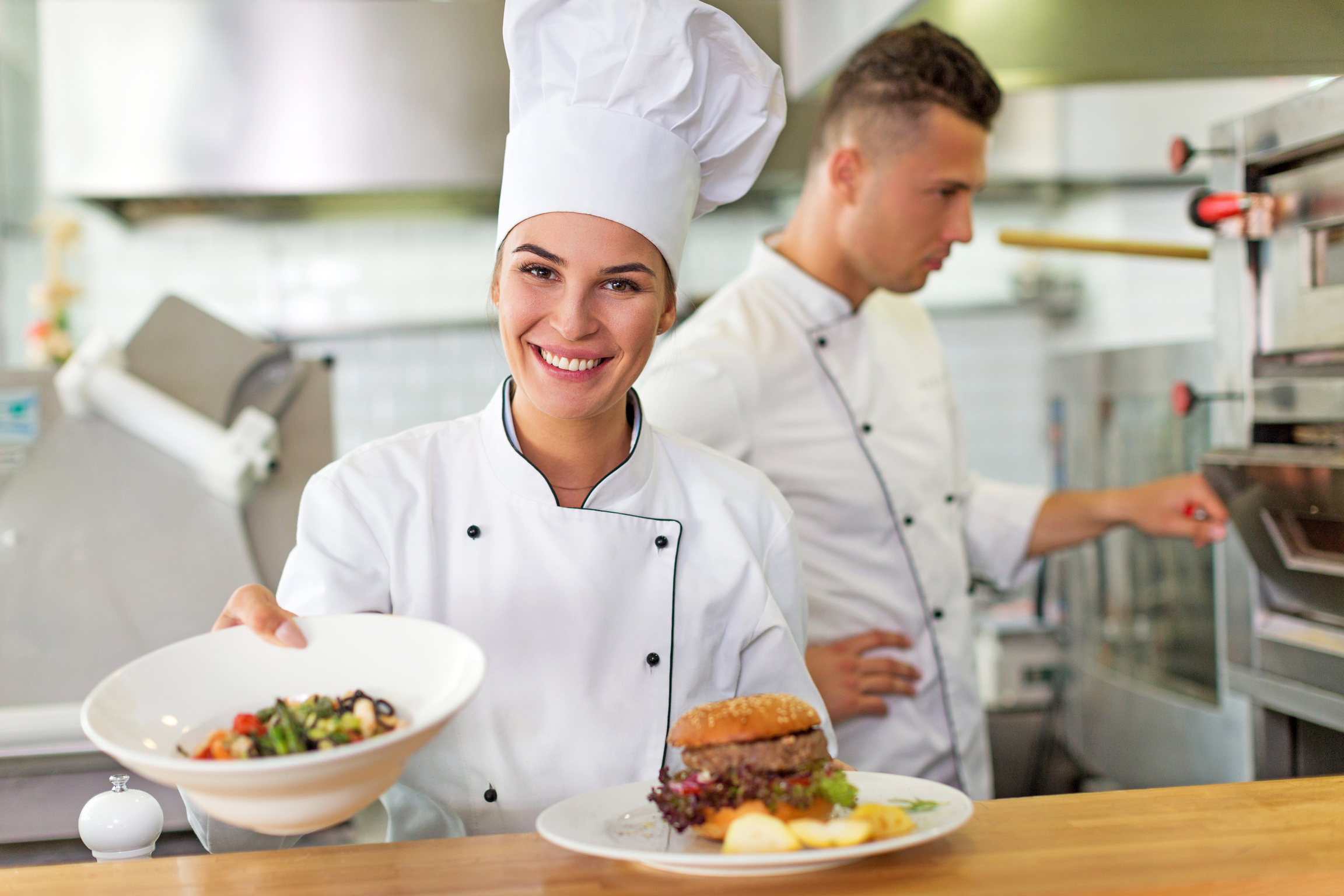 Two smiling chefs in kitchen